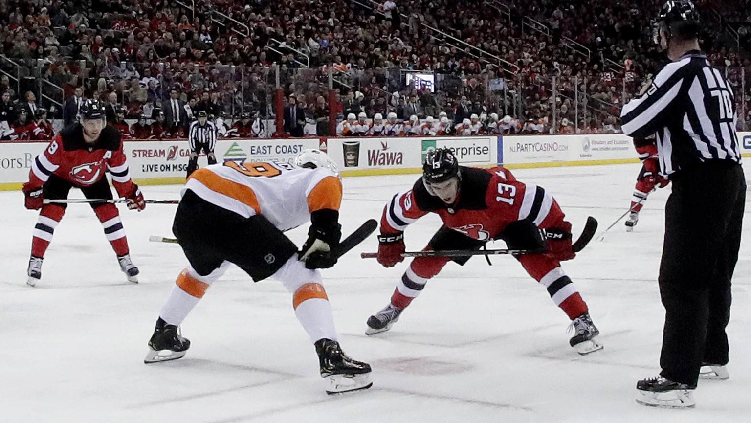 New Jersey Devils center Nico Hischier (13), of Switzerland, and Philadelphia Flyers center Nolan Patrick (19) prepare for the puck drop during the second period of an NHL hockey game, Saturday, Jan.  ...