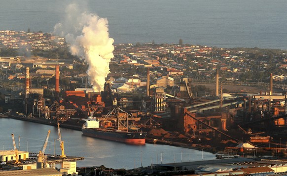 FILE - In this July 2, 2014 file photo, smoke billows out of a chimney stack of BHP steelwork factories at Port Kembla, south of Sydney, Australia. The world's biggest miner, BHP Billiton, on Tue ...