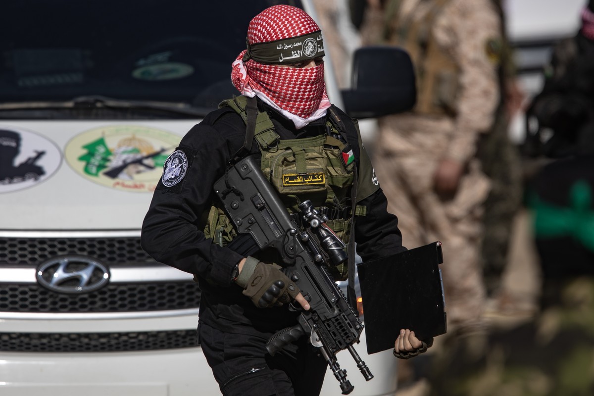 epa11897520 A fighter from Hamas's Izz ad-Din al-Qassam Brigade attends a ceremony to hand over three Israeli hostages to the Red Cross team, in Khan Yunis, southern Gaza Strip, 15 February 2025. ...