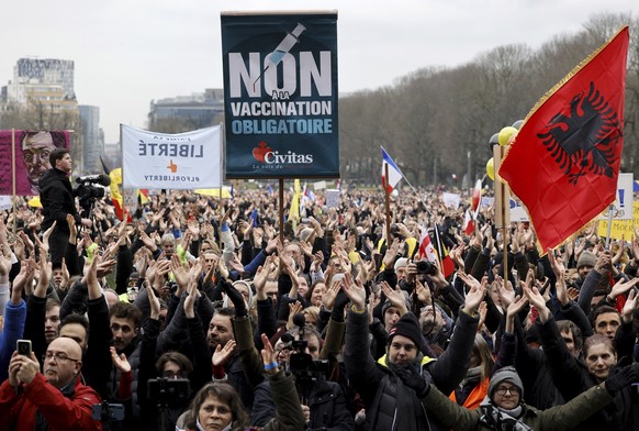 Protestors clap as they gather with signs and banners during a demonstration against COVID-19 measures in Brussels, Sunday, Jan. 23, 2022. Demonstrators gathered in the Belgian capital to protest what ...