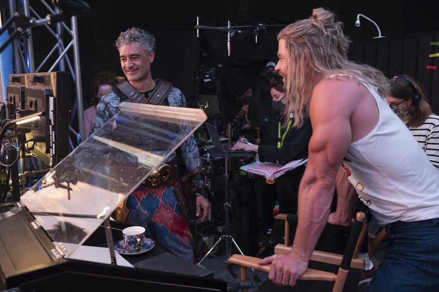 This image released by Marvel Studios shows director Taika Waititi, left, and Chris Hemsworth on the set of &quot;Thor: Love and Thunder.&quot; (Jasin Boland/Marvel Studios via AP)