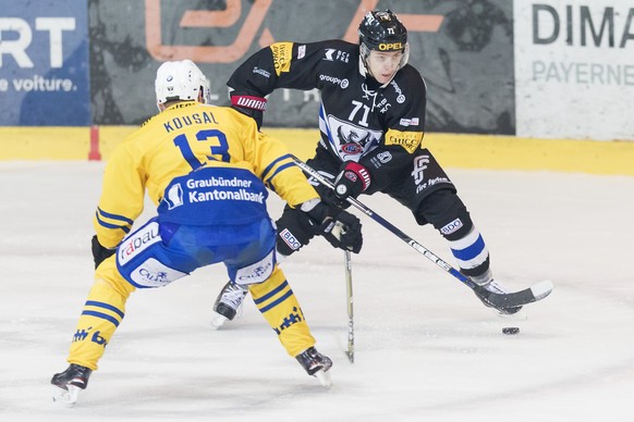 L&#039;attaquant davosiens Robert Kousal, gauche, lutte pour le puck avec l&#039;attaquant fribourgeois Killian Mottet, droite, lors du match du championnat suisse de hockey sur glace de National Leag ...