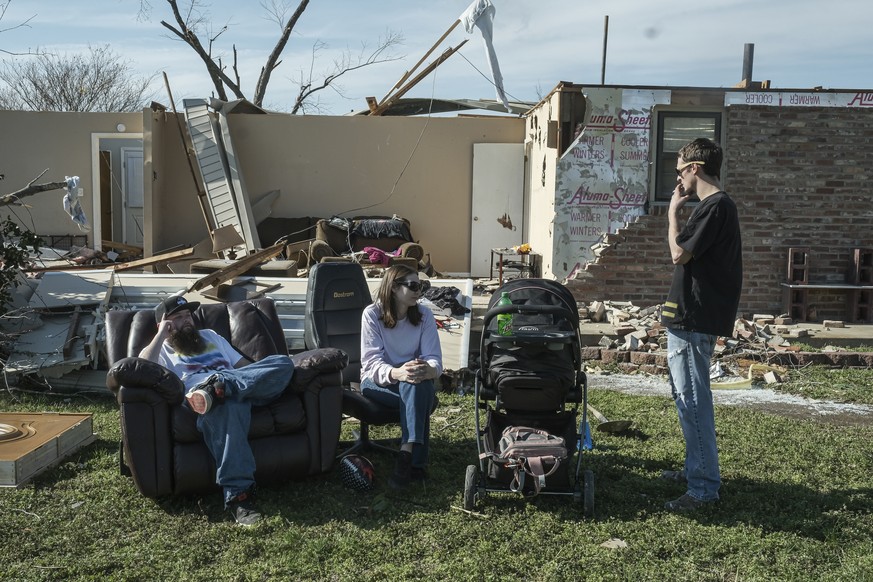 epa08268018 Will Green (L) sits amid the debris of a house where he lives with his father, that was damaged when a tornado struck Nashville, Tennessee, USA, 03 March 2020. His friends, Matthew and Ste ...
