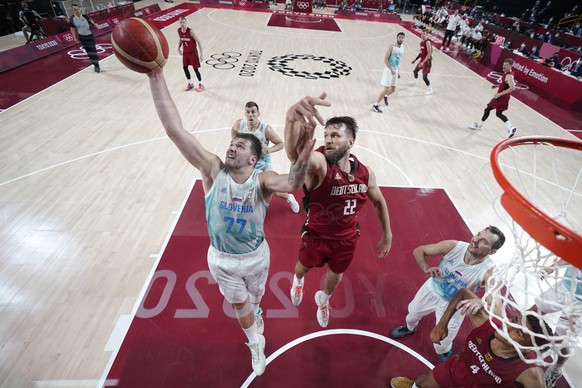 Slovenia&#039;s Luka Doncic (77) grabs a rebound ahead of Germany&#039;s Danilo Barthel (22) during a men&#039;s basketball quarterfinal round game at the 2020 Summer Olympics, Tuesday, Aug. 3, 2021,  ...