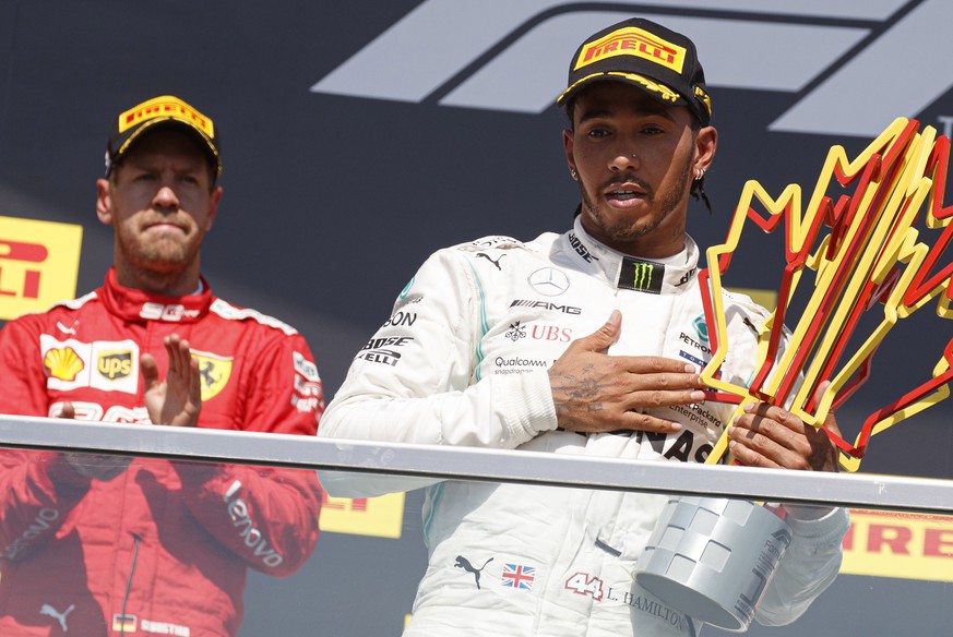 epa07637784 British Formula One driver Lewis Hamilton of Mercedes AMG GP (R) and German Formula One driver Sebastian Vettel of Scuderia Ferrari (L) react on the podium after the 2019 Canada Formula On ...