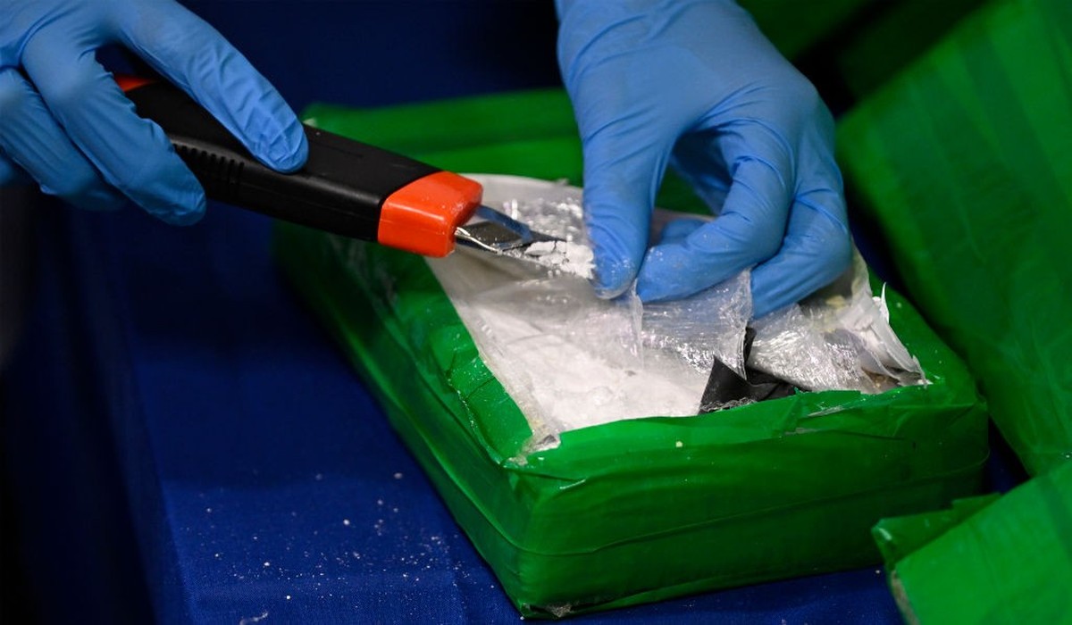 LISBON, PORTUGAL - DECEMBER 30: A Judiciary Police technician wearing protective gloves opens one of the impounded packages of cocaine on display at tthe Judicial Police headquarters on December 30, 2 ...