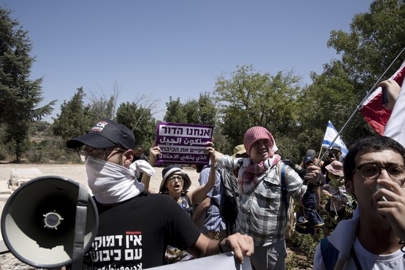 Israelis stand at the grave of Baruch Goldstein, a Jewish extremist who massacred 29 Muslim worshipers at Hebron's Ibrahimi Mosque in 1994, and protest at the home of the far-right National Security Council...