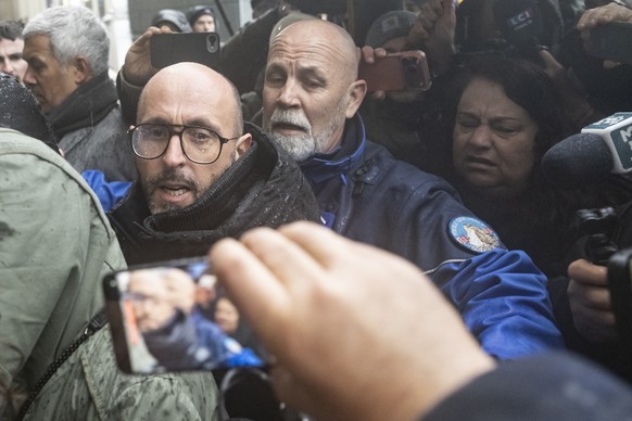 The owner of "Le Constellation" bar in Crans-Montana, Jacques Moretti of France, left, is screamed at by a mother of a victim, right, ahead of the hearing before the public prosecutor of the ...