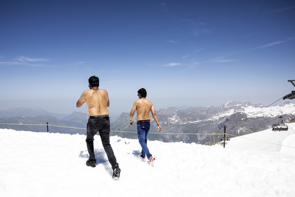 Zwei indische Touristen geniessen die sommerlichen Temperaturen auf dem Titlis im Schnee am Mittwoch, 26. Juni 2019. (KEYSTONE/Alexandra Wey)