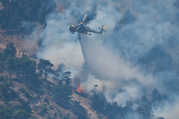 A firefighting helicopter drops water over a wildfire on Mount Kithairon near Porto Germeno, northwest of Athens, Greece, Monday, Aug. 3, 2026. (AP Photo/Petros Giannakouris)
Greece Wildfires