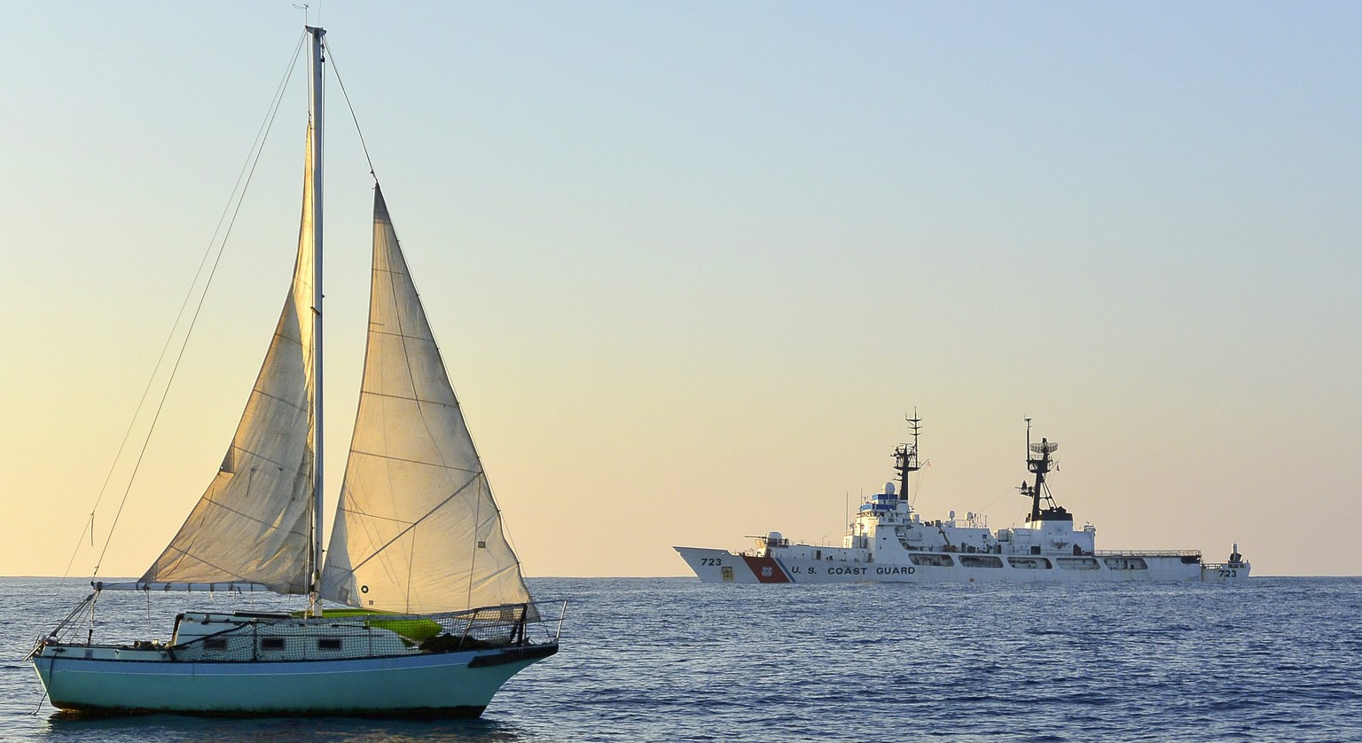 epa04524932 A handout photograph made available by the US Coast Guard on 11 December 2014 shows the 25 foot (7.62 meter) sailboat Malia as it is manned by coast guard personnel following the rescue of ...