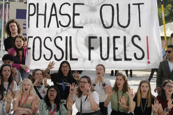 Activists demonstrate with a sign that reads &quot;phase out fossil fuels&quot; at the COP28 U.N. Climate Summit, Tuesday, Dec. 12, 2023, in Dubai, United Arab Emirates. (AP Photo/Peter Dejong)