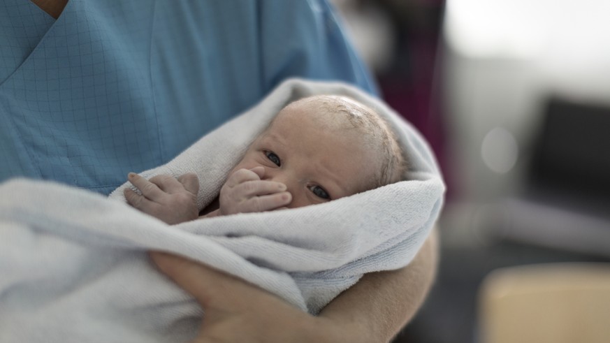 ZUM THEMA VATERSCHAFTSURLAUB STELLEN WIR IHNEN HEUTE, MITTWOCH, 25. OKTOBER 2017, FOLGENDES BILDMATERIAL ZUR VERFUEGUNG --- A midwife holds a newborn infant named Julia at the maternity unit of the Tr ...