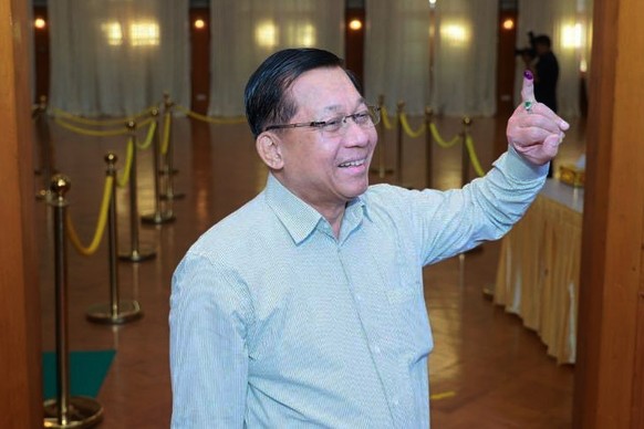 In this photo provided by the Myanmar Military True News Information Team, Myanmar's Senior Gen. Min Aung Hlaing shows off his finger marked with ink indicating he voted as he leaves a polling st ...