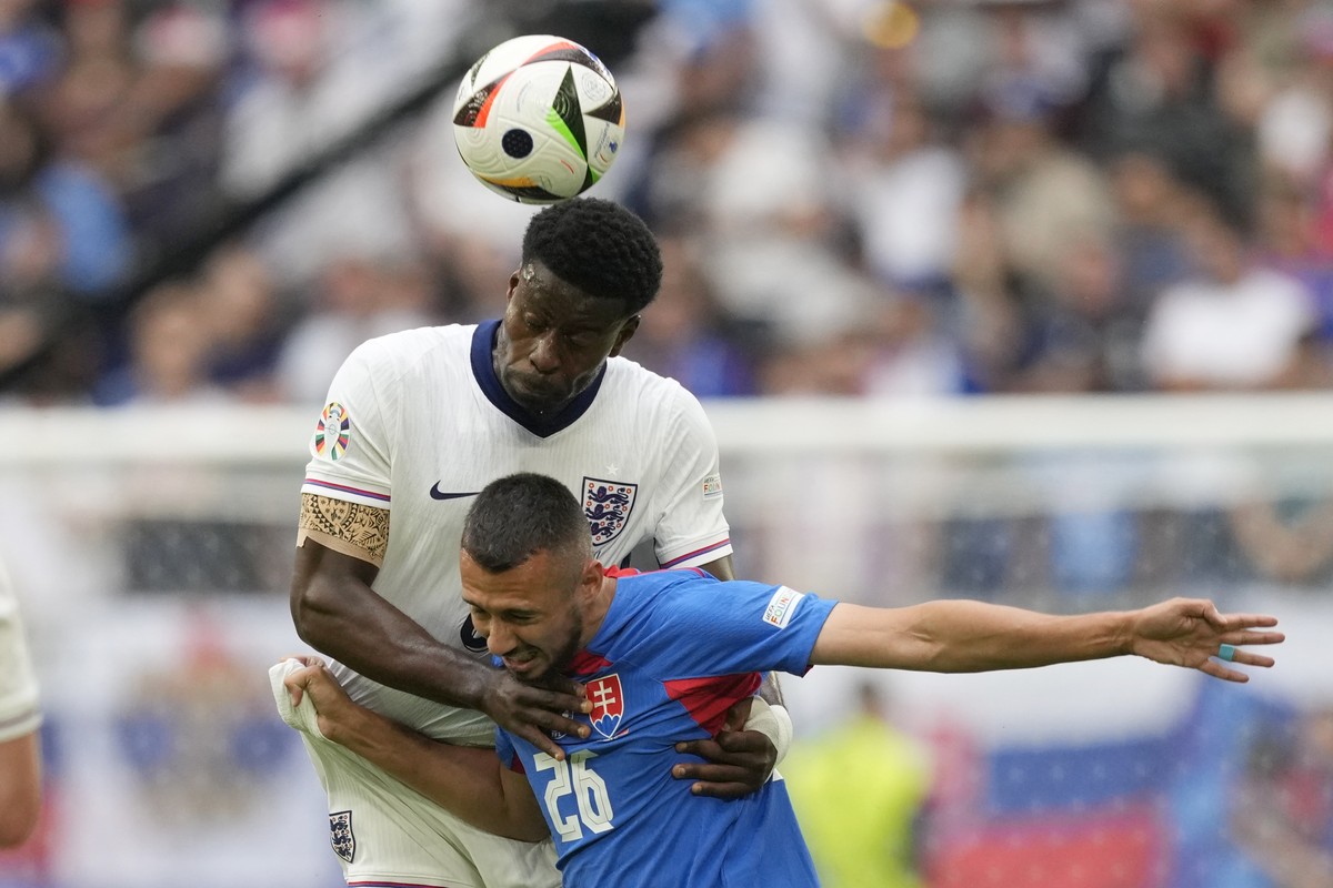 England's Marc Guehi, top, heads the ball past Slovakia's Ivan Schranz during a round of sixteen match between England and Slovakia at the Euro 2024 soccer tournament in Gelsenkirchen, Germa ...