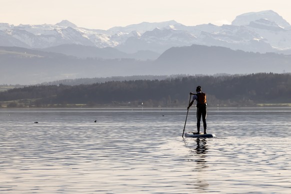 A man paddles on his stand up paddle board on the lake Greifensee on a sunny New Year&#039;s Day in the village of Greifensee near Zurich, Switzerland on Sunday, January 1, 2023. (KEYSTONE/Michael Buh ...