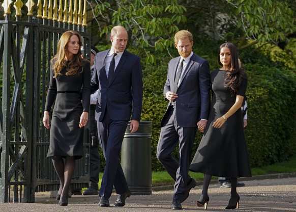 Britain&#039;s Prince William, second left, Kate, Princess of Wales, left, Britain&#039;s Prince Harry, second right, and Meghan, Duchess of Sussex view the floral tributes for the late Queen Elizabet ...