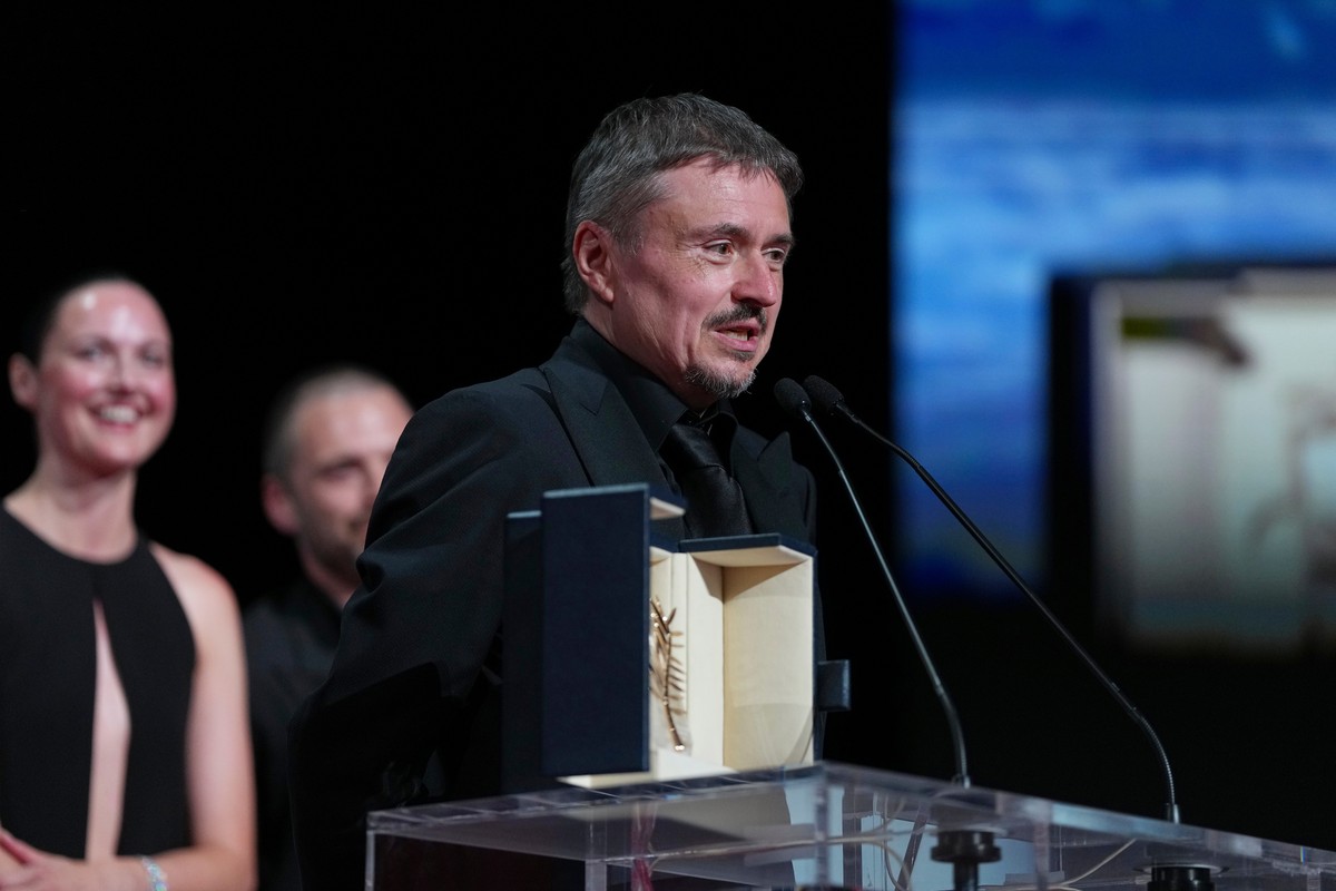 Cristian Mungiu accepts the Palme d'Or for 'Fjord' during the awards ceremony at the 79th international film festival, Cannes, southern France, Saturday, May 23, 2026. (AP Photo/Andreea ...