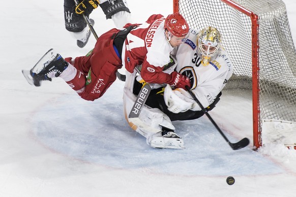 L&#039;attaquant lausannois Nicklas Danielsson, gauche, lutte pour le puck avec le gardien luganais Elvis Merzlikins, droite, lors de la rencontre du championnat suisse de hockey sur glace de National ...