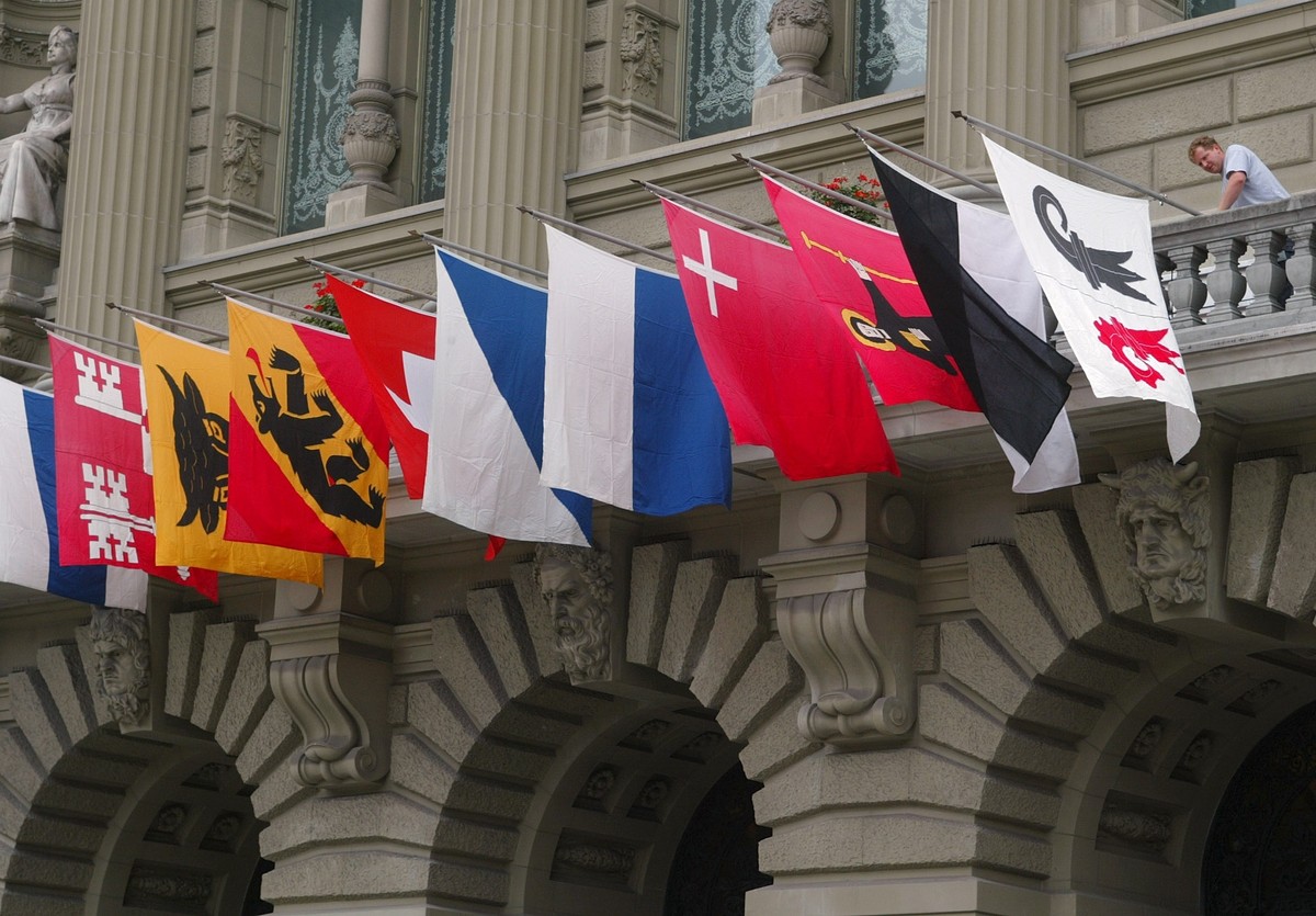 ARCHIV - Daniel May, stellvertretender Fahnenverwalter des Bundes, beflaggt am Donnerstag, 31. Juli 2003, in Bern, den Staenderatsbalkon des Bundeshauses mit den Kantons- und der Schweizerfahne fuer d ...