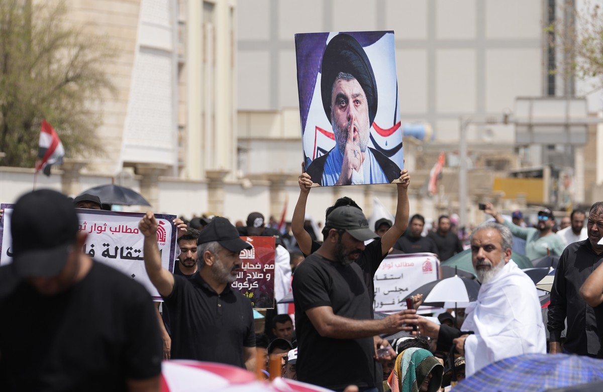 Supporters of Shiite cleric Muqtada al-Sadr with his poster gather during an open-air Friday prayers near the parliament building in Baghdad, Iraq, Friday, Aug. 26, 2022. Al-Sadr's supporters con ...