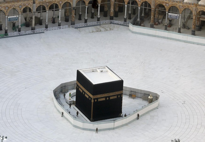 Saudi policemen guard the the Kaaba, the cubic building at the Grand Mosque, in the Muslim holy city of Mecca, Saudi Arabia, Friday, March 6, 2020. Saudi Arabia emptied Islam's holiest site for w ...