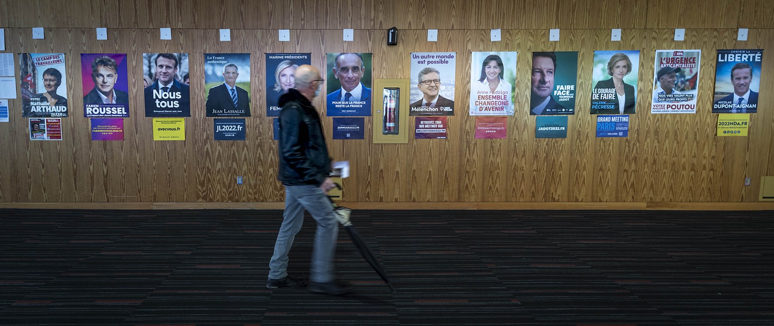 A French voter passes identification posters on his way to vote in the first round of the 2022 French presidential election, in Montreal, Saturday, April 9, 2022. (Peter McCabe/The Canadian Press via  ...