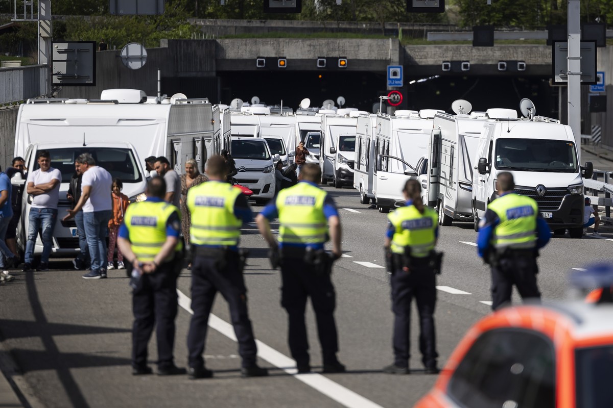 Les membres de la police cantonale valaisanne bloquent un convoi d'une quarantaine de caravanes de gens du voyage sur l'autoroute A9 le mardi 15 avril 2025 a St-Maurice en Valais. (KEYSTONE/ ...