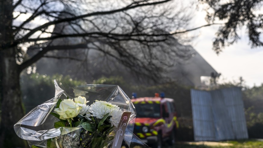 A bouquet of flowers is placed in tribute near a fire engine in front of a villa where four bodies were found after a fire, in Yverdon-les-bains, Switzerland, Thursday, March 9, 2023. An explosion fol ...