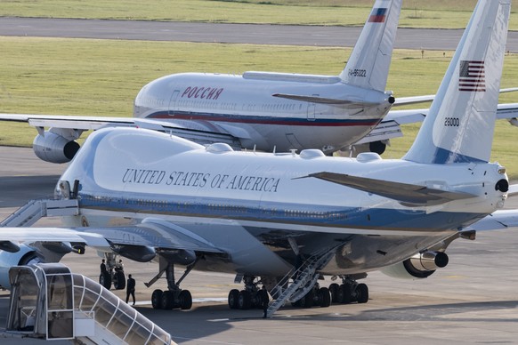epa09277732 Air Force One, the airplane of the US President, stands by, as the Presidential Ilyushin Il-96 (tail number RA-96022), presumably carrying Russian president Vladimir Putin, taxies to the r ...