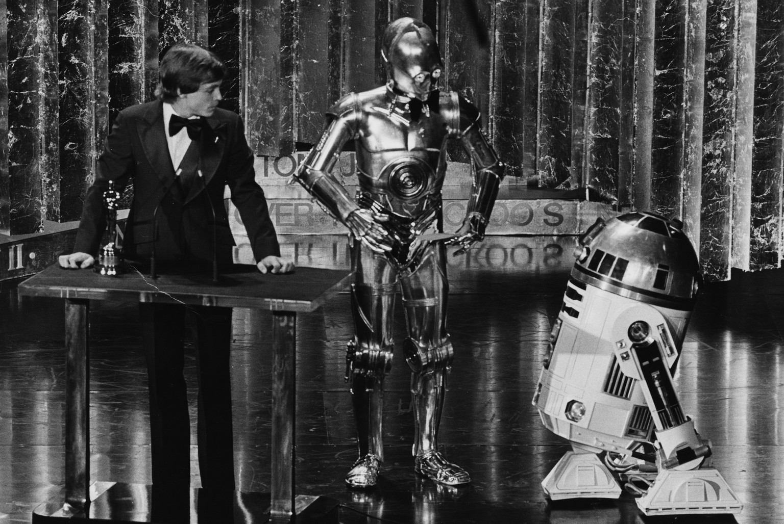 Mark Hamill präsentiert zusammen mit C3PO und R2-D2 einen Award an den 1978er Oscars.  
