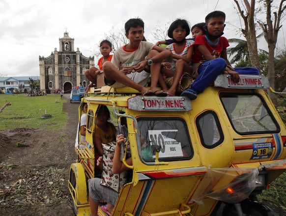 epaselect epa08790404 Filipino evacuees ride a three wheeled motorcycle in the typhoon-hit town of Sagnay, Camarines Sur, Philippines, 01 November 2020. Super Typhoon Goni, with winds forecasted to re ...