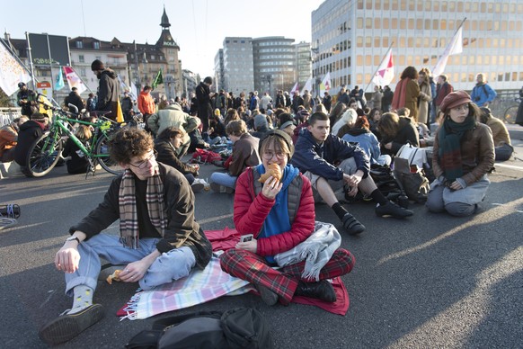 Des manifestant bloquent le Pont Chauderon en prenant le petit-dejeuner lors d’une manifestation en musique du groupe Extinction Rebellion en faveur du climat lundi 15 avril 2019 a Lausanne. (KEYSTONE ...