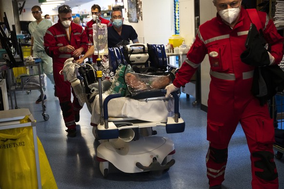 Medical personnel wheel a bed with a coronavirus patient as they prepare to transfer the patient by helicopter from the COVID-19 intensive care unit of the CHU Liege hospital to another hospital in Ge ...