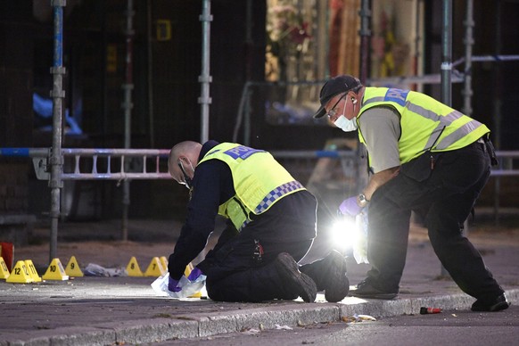 epa06819925 Police forensics search the scene after four people were shot and injured on an open street in central Malmo, southern Sweden, on 18 June 2018. Police have no information on suspects so fa ...