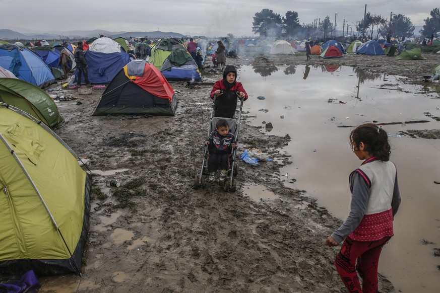 epa05202583 Refugees gather in a camp at the border between Greece and the Former Yugoslav Republic of Macedonia (FYROM), near Idomeni, northern Greece, 09 March 2016. Greece estimates that more than  ...