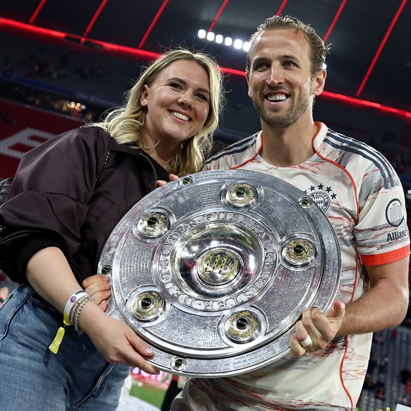 epa12089823 Harry Kane of Bayern Munich (R) celebrates the German Bundesliga championship title with his wife Katie Goodland (L) after the German Bundesliga soccer match between FC Bayern Munich and B ...