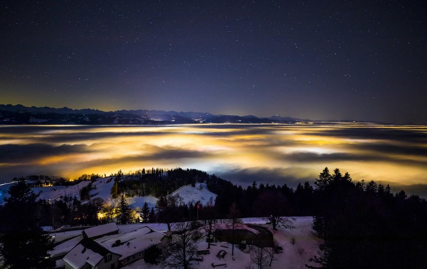 Die Sicht vom Bachtelturm in Richtung Zuercher Oberland. Die fleckenartige Beleuchtung entsteht durch die Lichter der Doerfer unter dem Hochnebel am Sonntag, den 24. Dezember 2017 oberhalb von Hinwil. ...