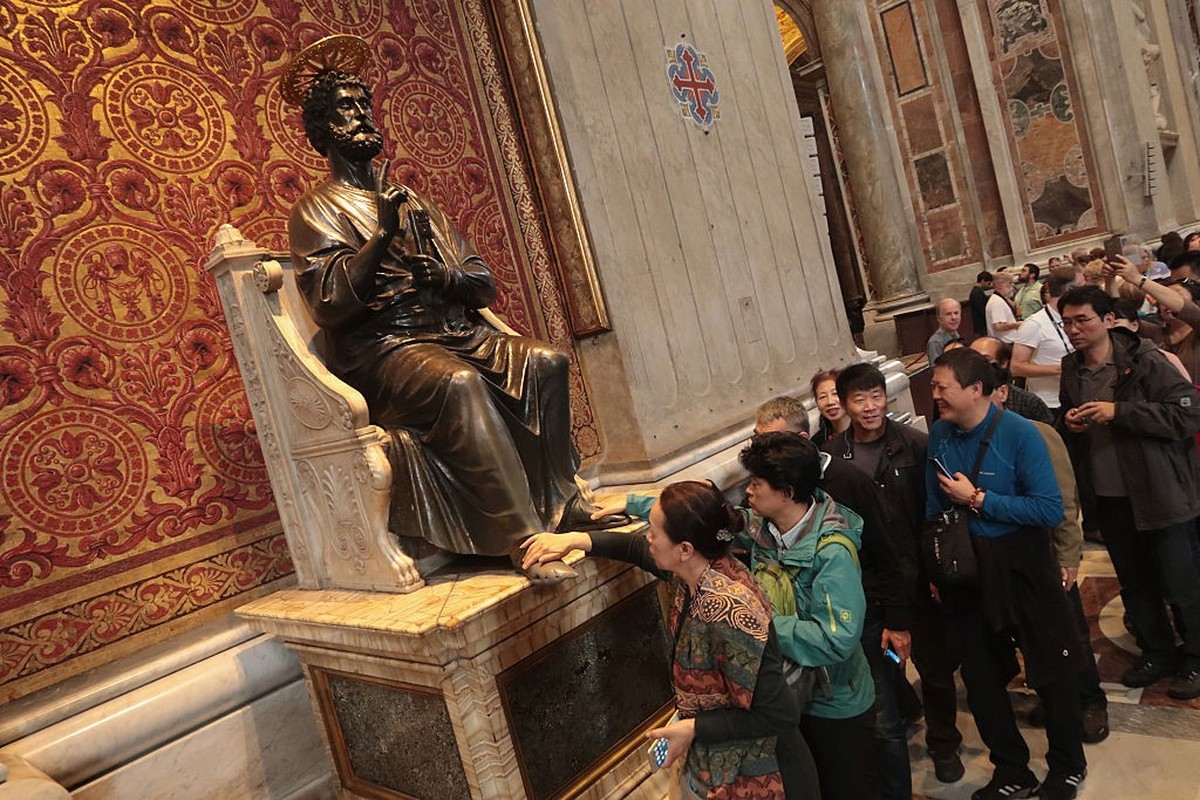 ROME, ITALY - OCTOBER 27: Visitors from Asia line up to touch the foot of a statue of Saint Peter holding the keys to Heaven in St. Peter's Basilica in Vatican City on October 27, 2016 in Rome, I ...