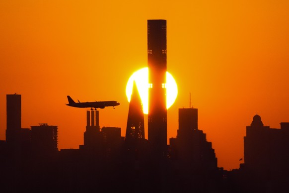 The sun sets behind the Manhattan skyline as plane approaches LaGuardia Airport for a landing before the quarterfinals match between Madison Keys, of the United States, and Marketa Vondrousova, of the ...