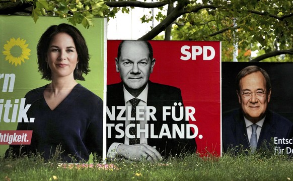 FILE - In This Thursday, Sept. 16, 2021 file photo, three elections posters show top candidate for chancellor of the Greens Annalena Baerbock, left, Social Democratic top candidate for chancellor Olaf ...