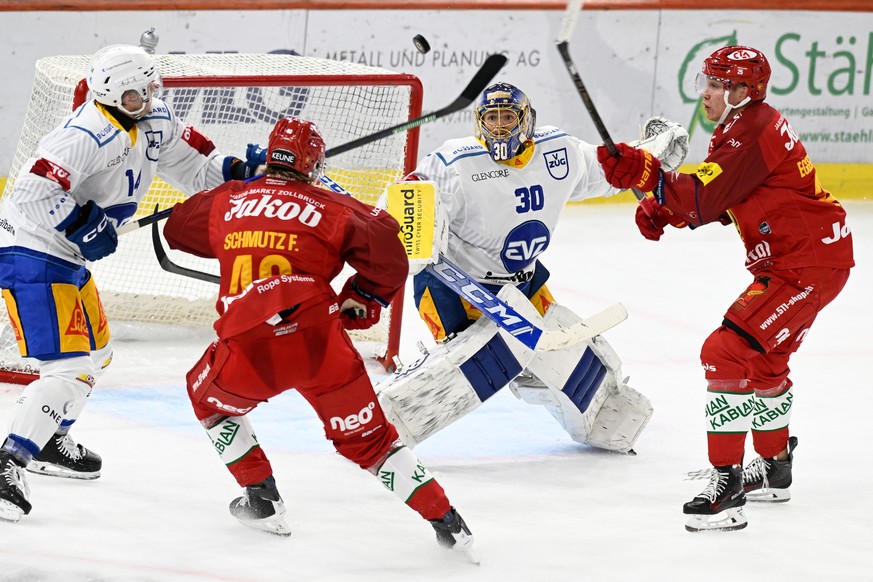 Tigers Flavio Schmutz, links, und Nando Eggenberger, rechts, im Kampf um den Puck gegen Zugs Livio Stadler, links, und Golaie Leonardo Genoni, beim Eishockey-Qualifikationsspiel der National League, z ...