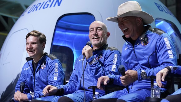 Oliver Daemen, left, and Jeff Bezos, right, founder of Amazon and space tourism company Blue Origin, laugh as Mark Bezos, center, makes comments after their flight experience from the spaceport near V ...