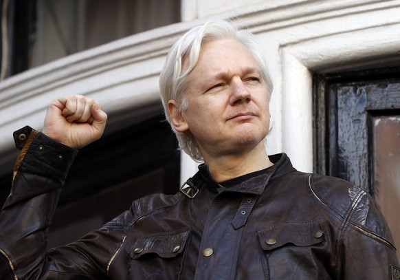 FILE - In this Friday May 19, 2017 file photo, Julian Assange greets supporters outside the Ecuadorian embassy in London. Britain