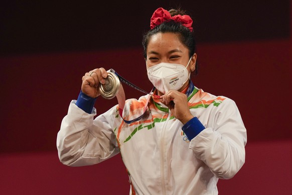 Chanu Saikhom Mirabai of India celebrates on the podium after winning the silver medal in the women&#039;s 49kg weightlifting event, at the 2020 Summer Olympics, Saturday, July 24, 2021, in Tokyo, Jap ...