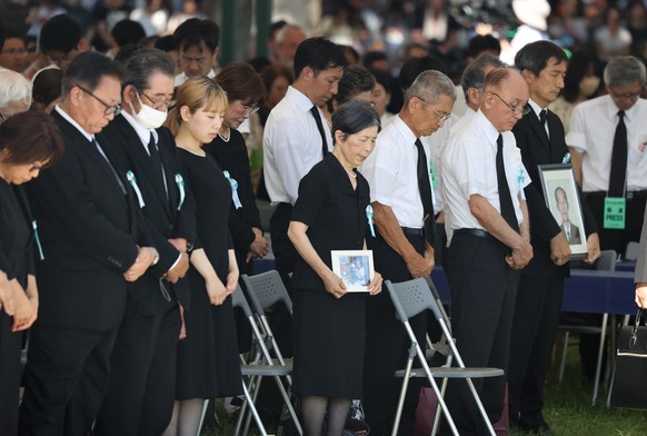 epa10786913 Attendants of the memorial service for victims of the atomic bombing of Hiroshima offer a one-minute silent prayer for the victims at Hiroshima Peace Memorial Park in Hiroshima, Hiroshima  ...
