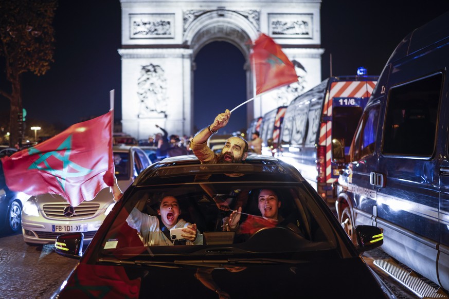 epaselect epa10352881 Moroccan supporters celebrate their team winning the FIFA World Cup 2022 round of 16 soccer match between Morocco and Spain, on the Champs Elysees avenue in Paris, France, 06 Dec ...