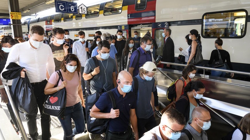 People wearing protective mask get out a SBB CFF train during the coronavirus disease (COVID-19) outbreak, at the train station CFF in Lausanne, Switzerland, Monday, July 6, 2020. In Switzerland, from ...