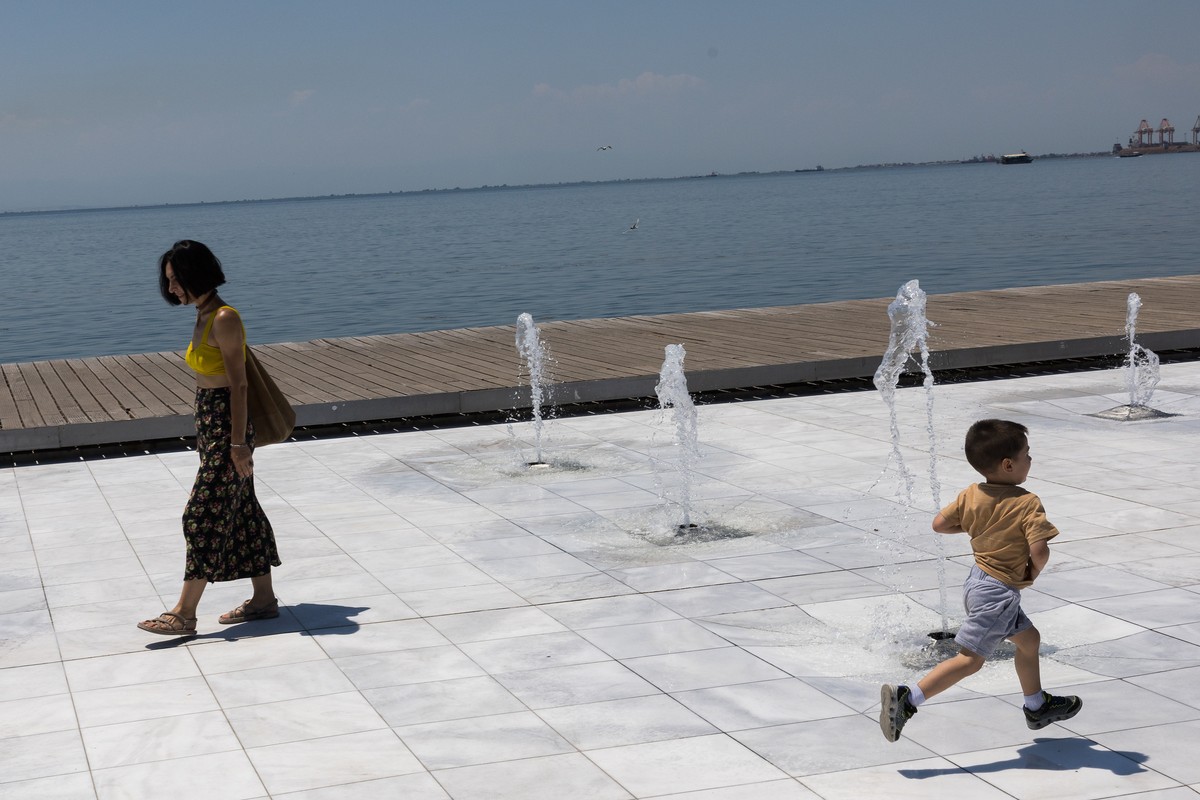 epa12222211 A child runs between fountains on a day with very high temperatures in Thessaloniki, Greece, 07 July 2025. Very high temperatures are forecast in Greece until 09 July. The highest temperat ...