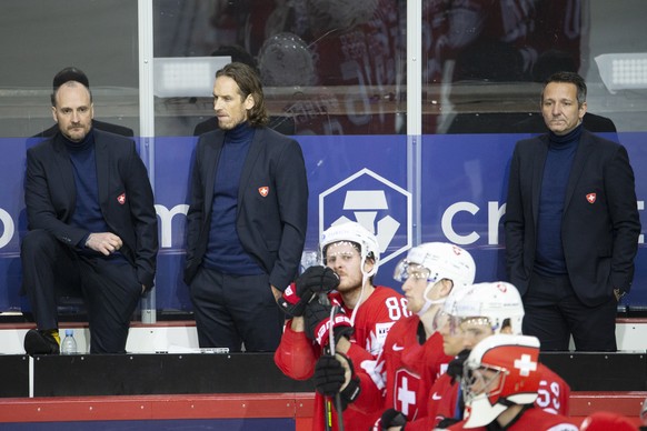 epa09245472 Switzerland's head coach Patrick Fischer (2-L) and his assistants Christian Wohlwend (L) and Marco Bayer (R) react after the IIHF Ice Hockey World Championship 2021 quarter final game betw ...